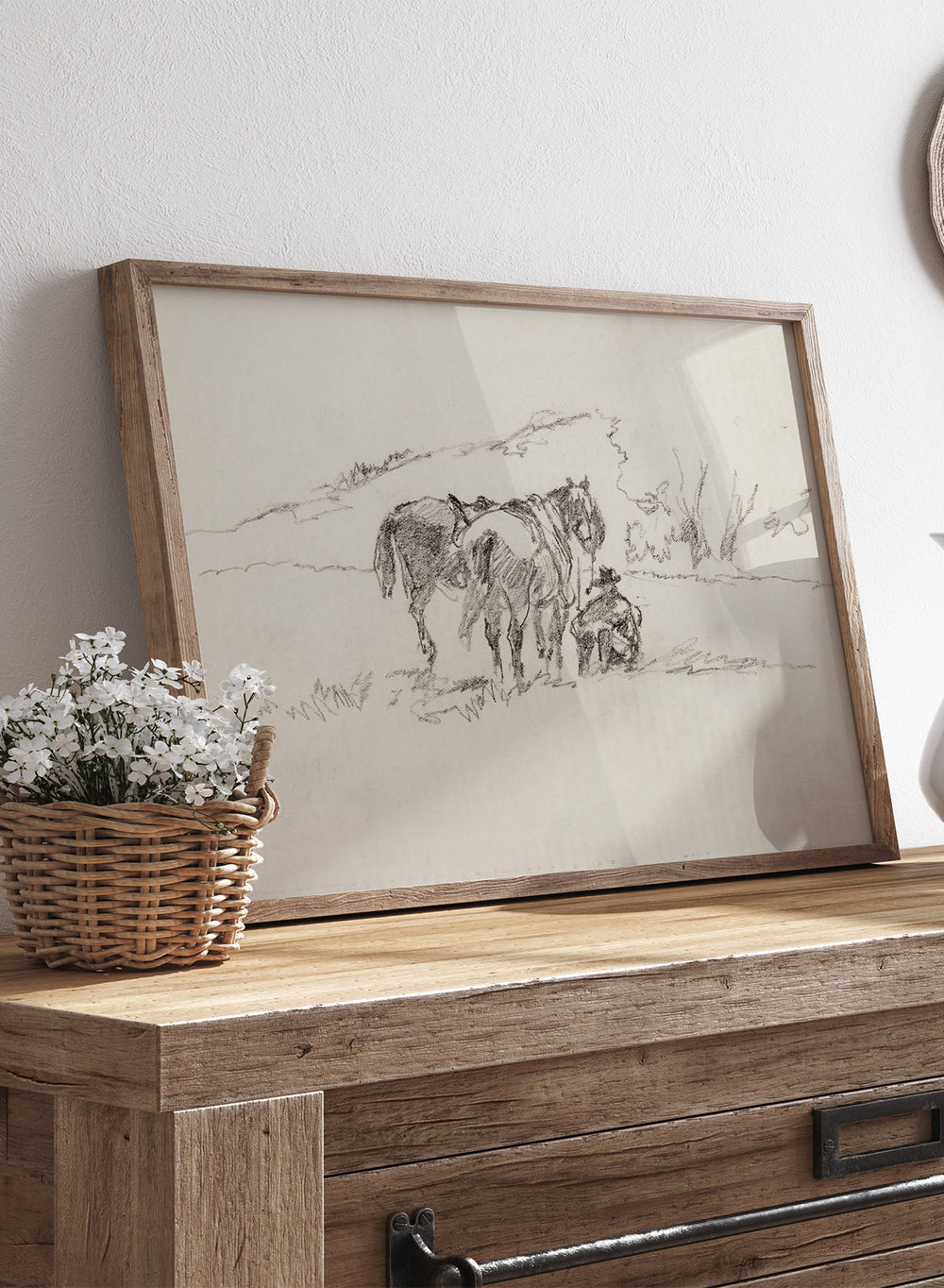 A framed black and white sketch print depicting a cowboy and horse, set against a light beige background. Sketch Made on Indian Reservation, Montana by Walter Shirlaw is a vintage horse sketch featuring a seated figure, grazing horses, and the Montana landscape.