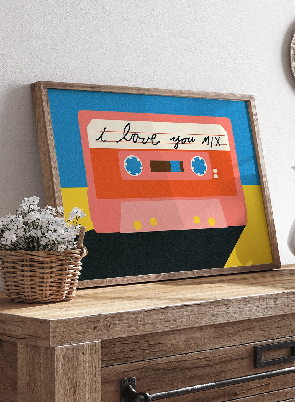 Illustration of a cassette tape with 'I love you mix' text on a blue and yellow background. I Love You Mix Tape by Rosi Feist is a bold pop art print of a retro cassette with a handwritten love note. Officially licensed wall poster with framing.