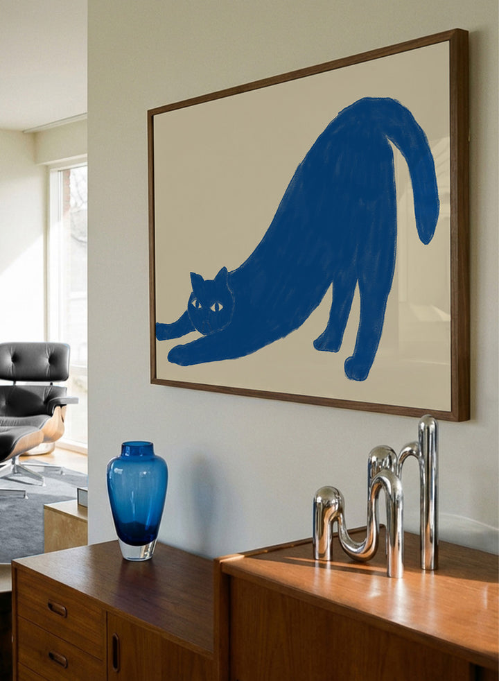 Framed wall art featuring a blue cat stretching on a beige background. Stretching Blue Cat by The Art Concept is a playful cat art print featuring a blue stretching cat on a warm cream background in a simple modern style.