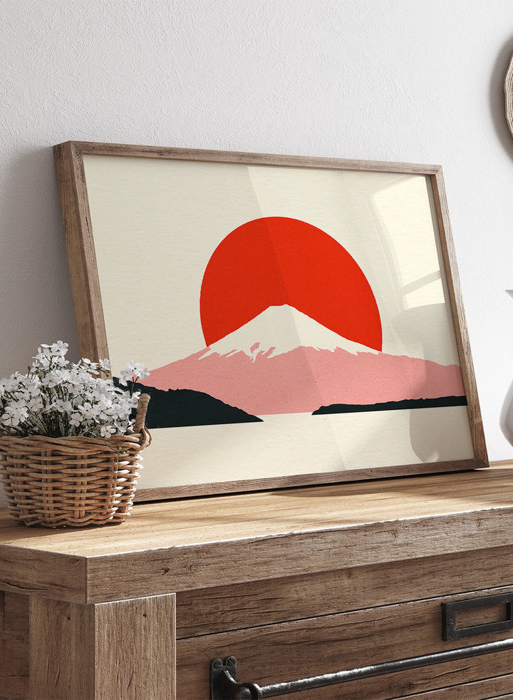 Framed artwork of a mountain with a red sun on a beige background. Fuji Sun by Rosi Feist is a modern Japanese landscape art print featuring Mount Fuji, a bold red sun, and minimalist contemporary poster design.