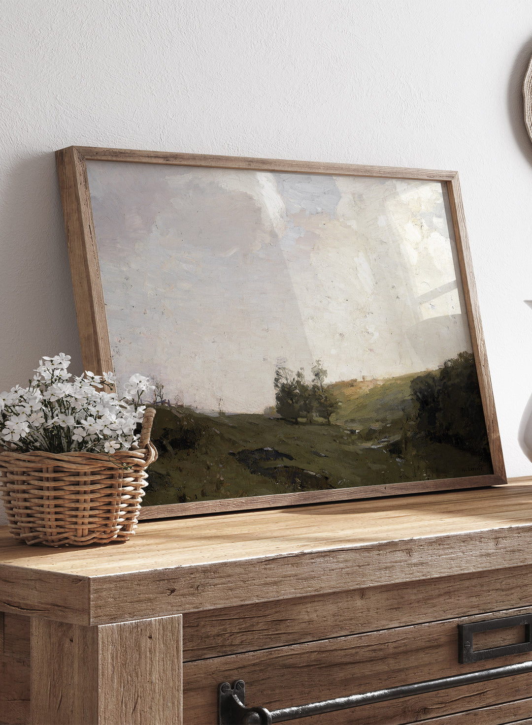 The Three Trees by William Langson Lathrop is a vintage tonalist landscape print of a green field and cloudy sky, a calming countryside wall art print.