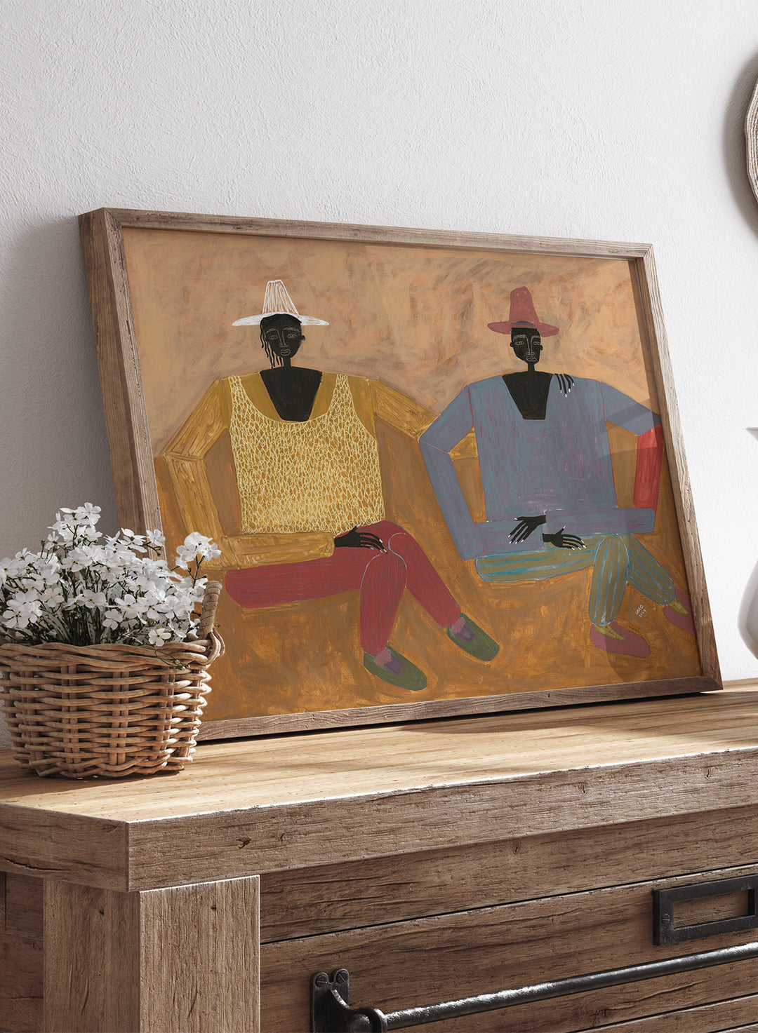 Framed artwork of two people sitting on a bench with a plain background. Still, Together by Studio IMO (Ibi Meier-Oruitemeka) is a modern figurative art print with two seated figures in a contemporary wall poster design.