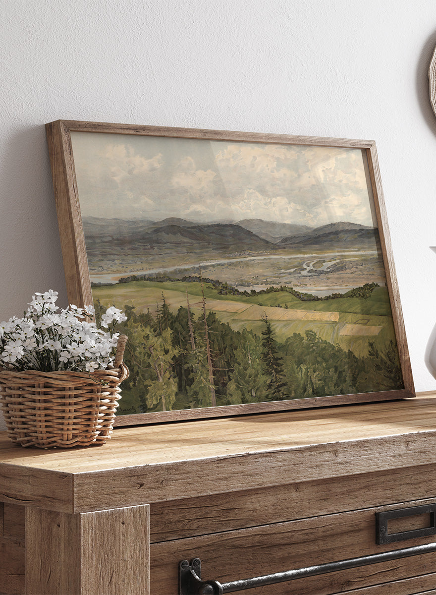 A framed landscape art print depicting rolling green and tan fields, distant mountains, a winding river, and a cloudy sky. Mountain Landscape by Arkadi Afanasyevich Chumakov is a vintage landscape art print featuring forest, fields, mountains, and a winding river.