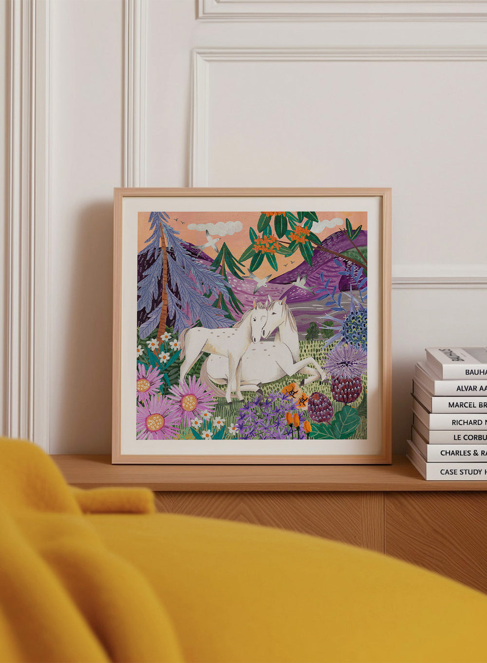 Framed artwork of two horses in a colorful forest scene with flowers and mountains. Horses in the Mountains by Caroline Bonne Müller is a fine art print and wall poster featuring two white horses surrounded by colorful flowers in a mountain landscape.