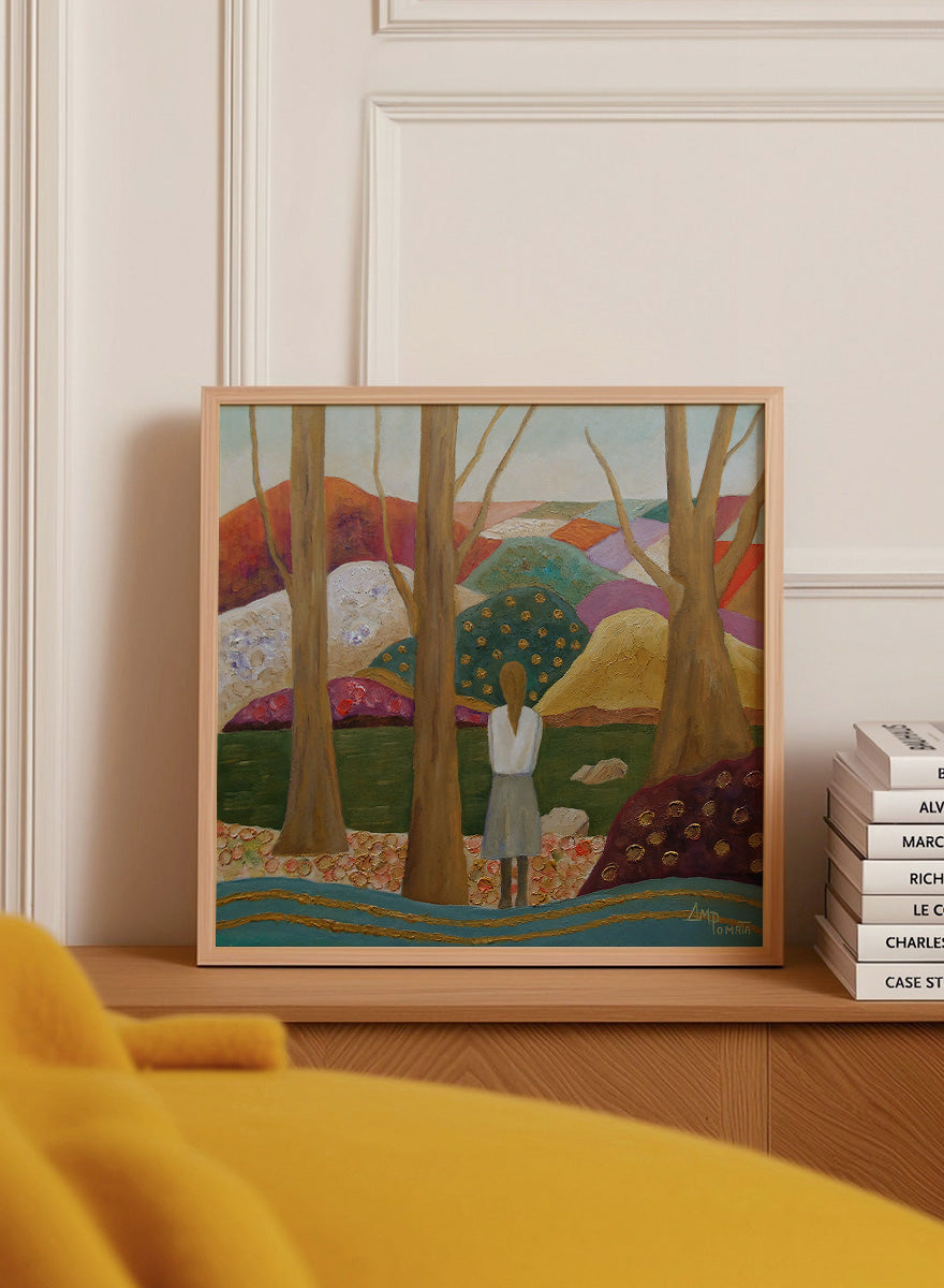 A framed landscape painting featuring a woman standing among tall trees, looking over a patchwork field of hills in earthy tones of green, purple, orange, and beige. Shop Woman Among Vibrant Hills by Angeles M. Pomata, a colorful landscape and portrait art print featuring a woman, rolling hills, trees, and earthy tones.