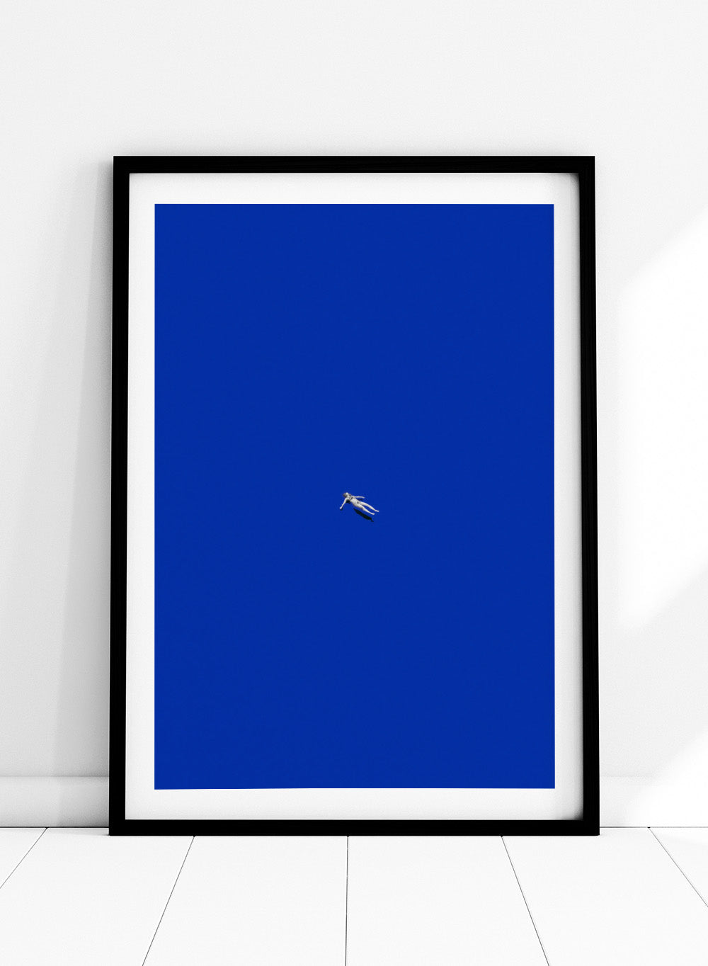 No Stress by Maarten Léon is a minimalist collage art print featuring a floating figure in a bold blue space. Premium fine art print with real wood framing.