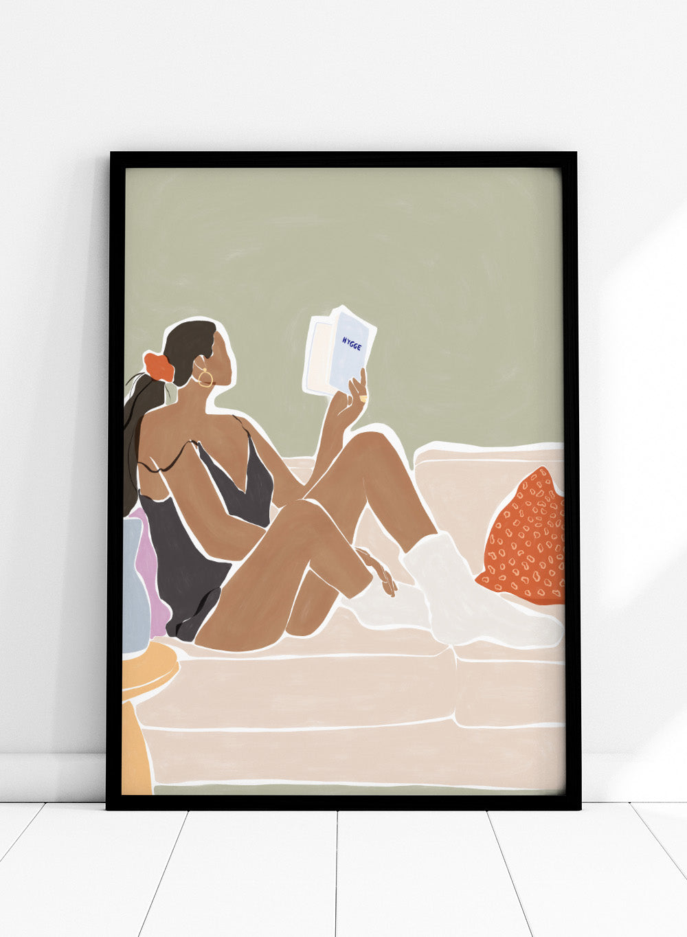 Woman Enjoying a Great Hygge Book by Ivy Green is a cozy modern figure art print celebrating slow living and self-care. Premium fine art print with optional wood framing.