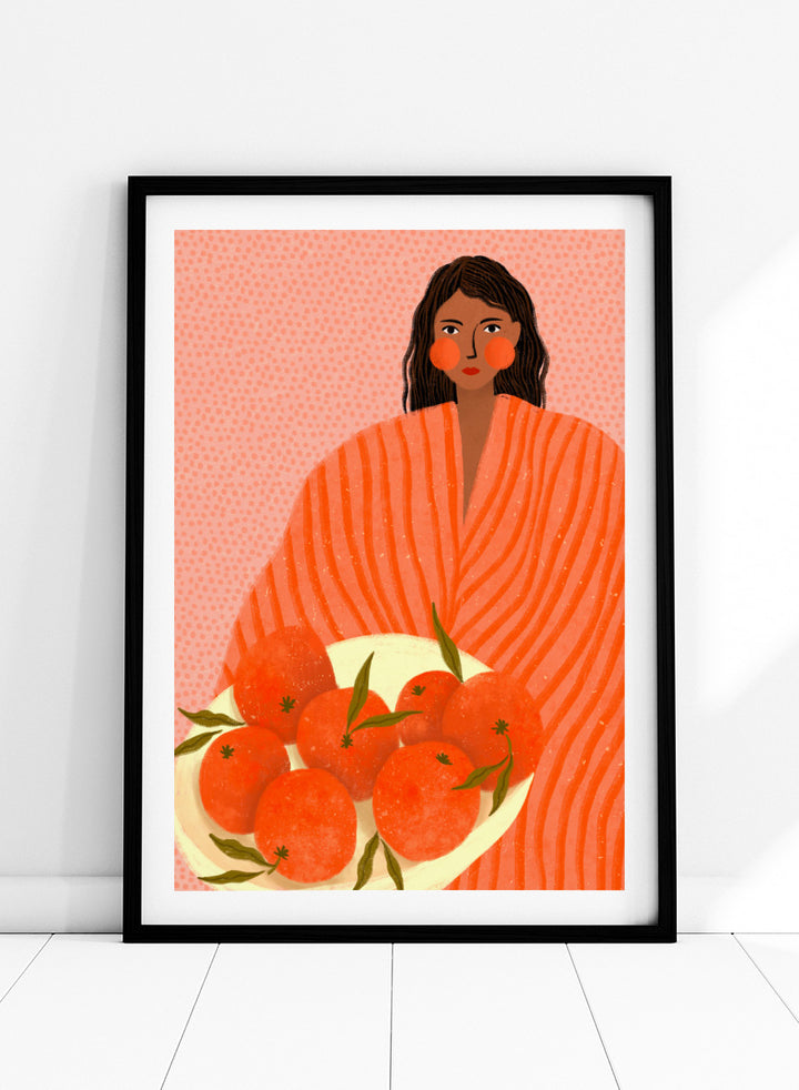 A stylized art print featuring a woman with dark hair wrapped in a bright orange striped blanket, holding a white plate of oranges against a pink dotted background. Woman Holding Oranges by Bea Müller colorful kitchen art print featuring a woman carrying fresh citrus fruit in warm orange and coral tones.