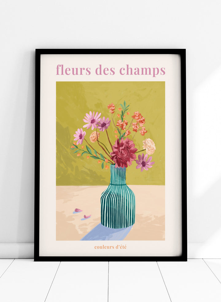 Illustration of a vase with flowers on a green background, featuring the text 'fleurs des champs' and 'couleurs d'ete'. Fleur Des Champs Green by Goed Blauw is a colorful floral art print and wall poster featuring a striped vase with loose flowers on a warm yellow background.