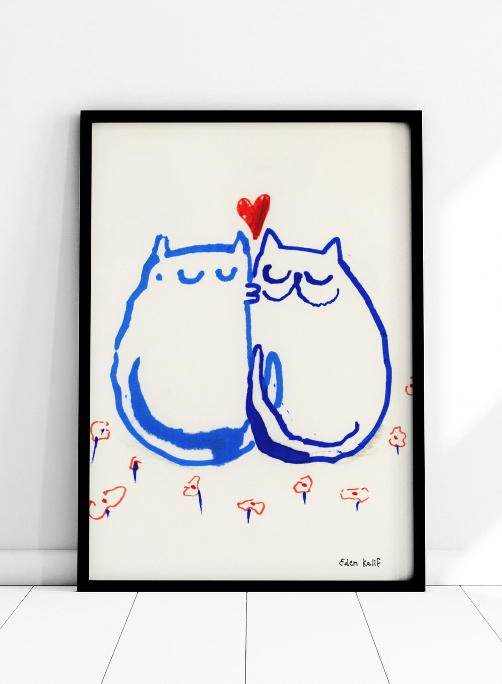 Two blue cats holding a red heart with small colorful flowers around on a white background. Lovin’ Cats by Eden Kalif is a modern cat art print with two figures and a red heart, a contemporary minimalist wall poster with playful form and expressive line work.