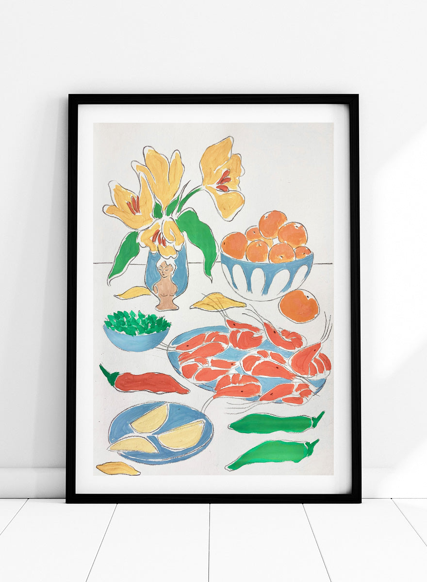 A framed still life art print featuring yellow tulips in a blue vase, bowls of oranges, red shrimp, green peppers, and yellow lemon wedges. Shop Fresh Flowers and Feast by Rushati Chowdhury, a colorful food and floral art print featuring shrimp, oranges, peppers, greens, lemon, and yellow flowers.