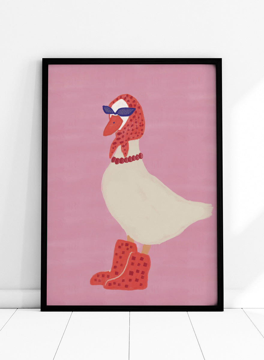 A stylized illustration of a white goose wearing a red patterned headscarf, blue sunglasses, a red beaded necklace, and red checkered boots, set against a solid pink background. Chic Goose Fashion by The Art Concept playful animal art print featuring a goose in sunglasses, a red headscarf, necklace, and bold red boots.