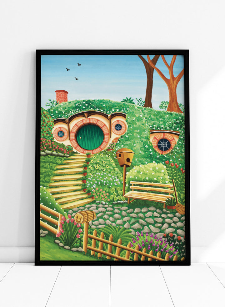 A colorful fantasy-style illustration of a hobbit hillside scene with a round green door, stone steps, flowers, trees, a bench, and a birdhouse under a blue sky. Shop Whimsical Hill House by Nidhi Kachhadiya, a colorful cottage wall art print featuring a garden home, lush greenery, flowers, and playful storybook details.