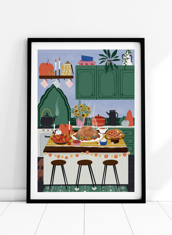 A framed art print depicting a cozy, stylized autumn kitchen scene with a large roasted turkey on a table covered in fall dishes, green cabinets, pumpkins, and three bar stools. Cozy Thanksgiving Kitchen by Ceyda Alasar kitchen art print featuring a turkey feast, pie, pumpkins, flowers, candles, and warm autumn decor.