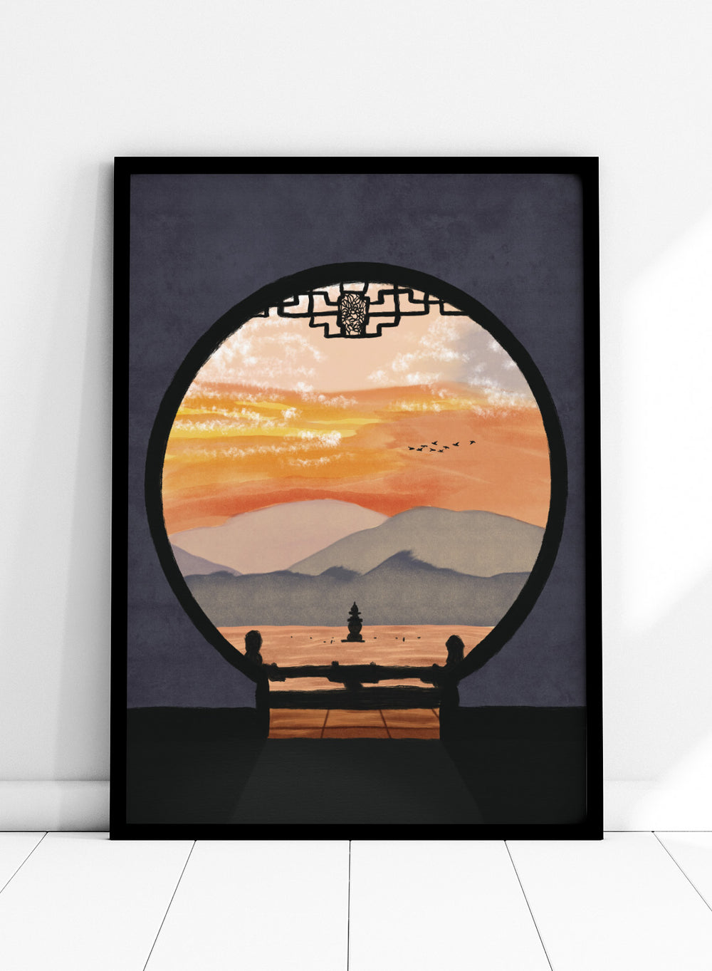 A framed art print depicting a scenic landscape viewed through a circular window frame. The scene shows layered mountains under a warm orange and yellow sunset sky with a small pagoda-like structure and birds, set against a dark gray background. Asian Pagoda Sunset View by Lisa Solomoniuk premium framed fine art print featuring layered mountains, a distant pagoda, and a glowing peach sunset.