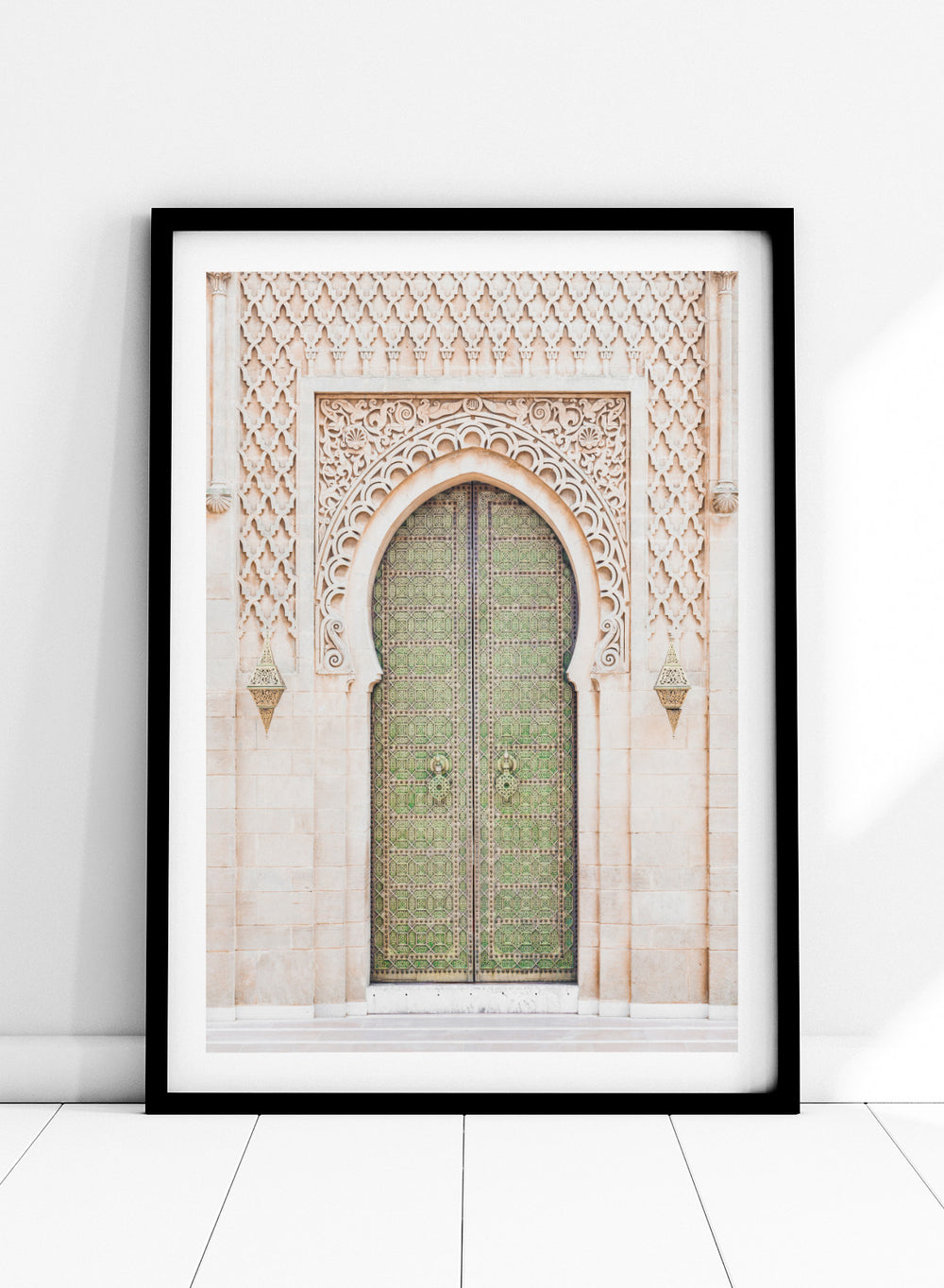 Decorative archway with ornate green door on a light stone wall. Ornate Moroccan Green Door by Henrike Schenk is a Moroccan architecture print featuring an ornate green door, Islamic patterns, and historic stone details.