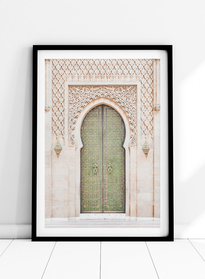 Decorative archway with ornate green door on a light stone wall. Ornate Moroccan Green Door by Henrike Schenk is a Moroccan architecture print featuring an ornate green door, Islamic patterns, and historic stone details.