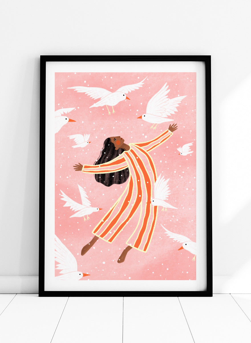 A framed art print featuring an illustration of a woman in orange and white striped pajamas floating among white doves on a soft pink background. Joyful Liberation by Bea Müller woman art print featuring a free-spirited figure surrounded by white birds in bold pink and orange tones.