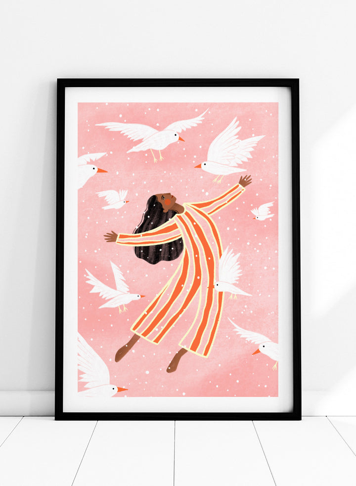A framed art print featuring an illustration of a woman in orange and white striped pajamas floating among white doves on a soft pink background. Joyful Liberation by Bea Müller woman art print featuring a free-spirited figure surrounded by white birds in bold pink and orange tones.