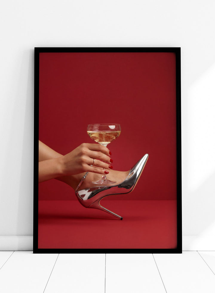 High-heeled shoe holding a glass of white wine against a red background, High Heels and Champagne by Andreas Magnusson is a fashion illustration art print featuring high heels, champagne glass imagery, bold red tones, and modern contemporary wall art style.