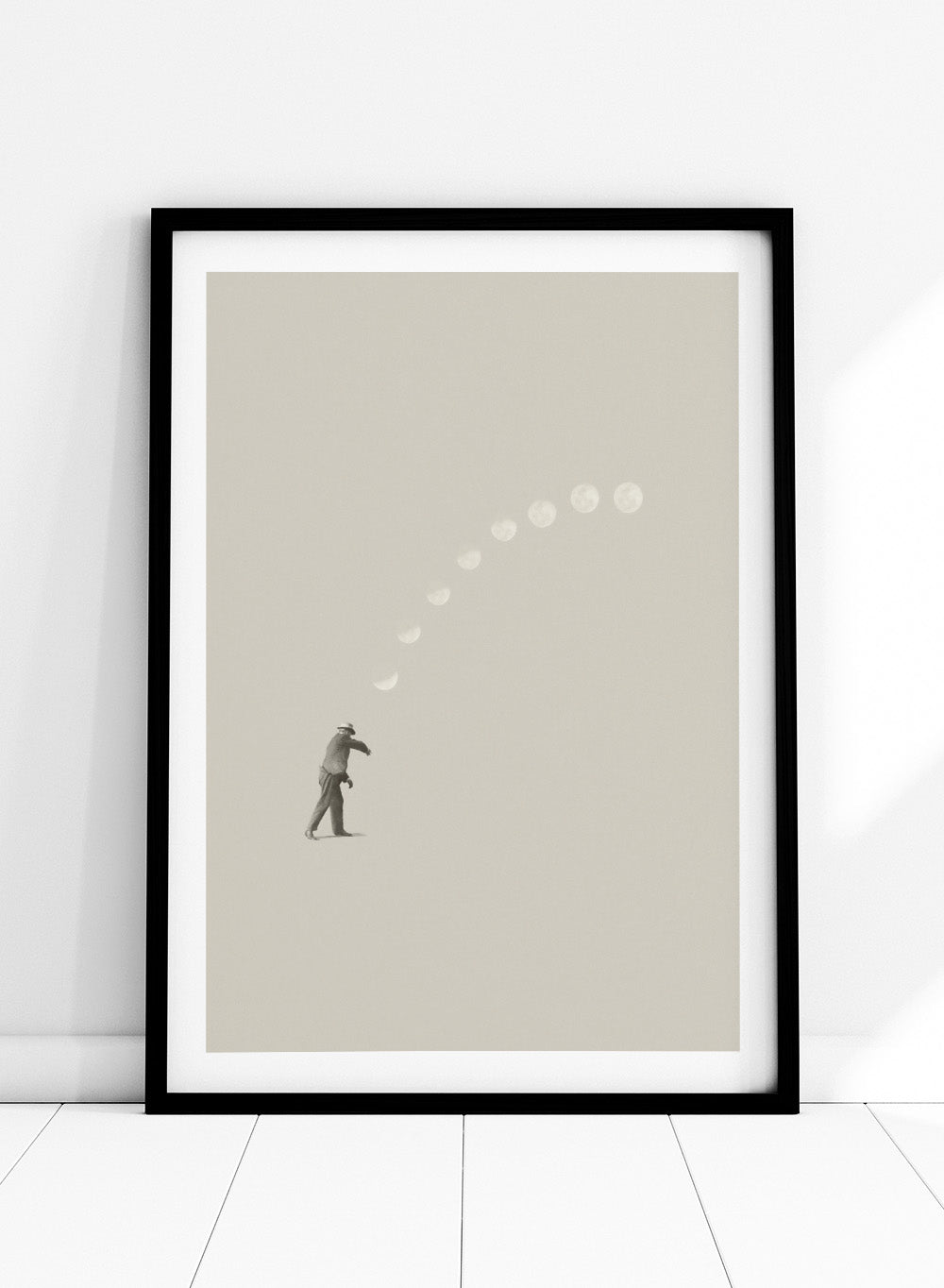 Man throwing the moon across the sky in Lucky Shot by Maarten Léon. Surreal collage wall art, minimalist contemporary poster, premium fine art with real wood frame.