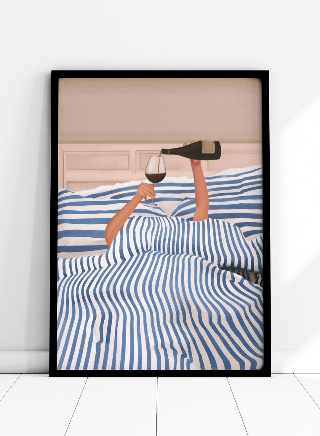 Person lying in bed pouring wine into a glass, wearing striped sheets. Wine In Bed by Flow Line is a playful art print featuring striped bedding, red wine, minimalist illustration, and cozy bedroom decor.