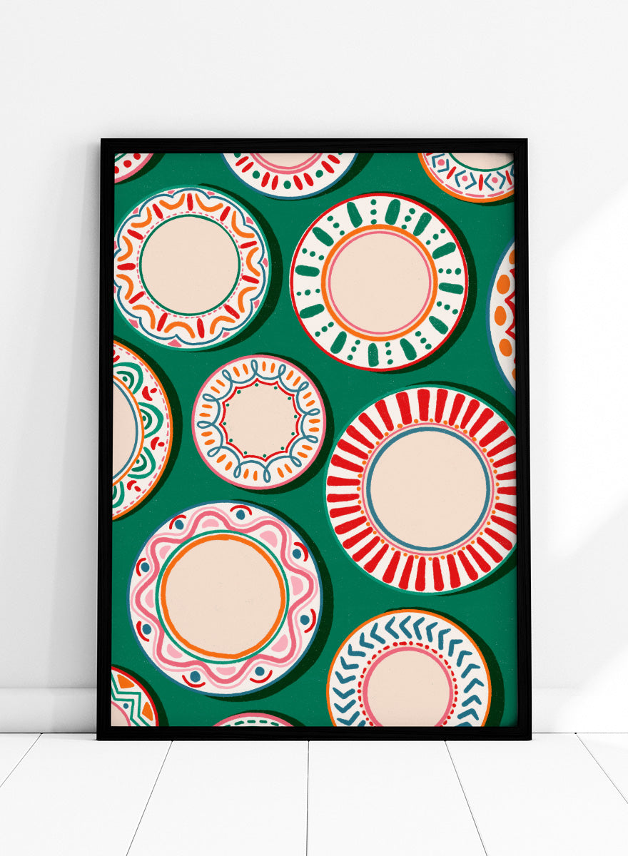 A flat-lay pattern of colorful decorative plates on a dark green background, featuring a variety of circular designs in red, orange, pink, blue, and cream. Shop Colorful Patterned Plates by Nidhi Kachhadiya, a playful kitchen wall art print featuring decorative plates, folk-inspired patterns, and bold green, red, and pink tones.