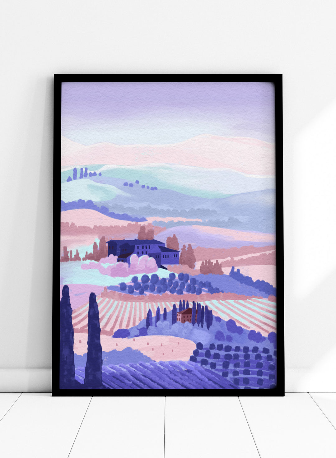Painting of a landscape with rolling hills, buildings, and cypress trees in pastel colors. Tuscany by Goed Blauw is a landscape art print and wall poster featuring rolling hills, fields, and countryside homes in soft pastel tones.
