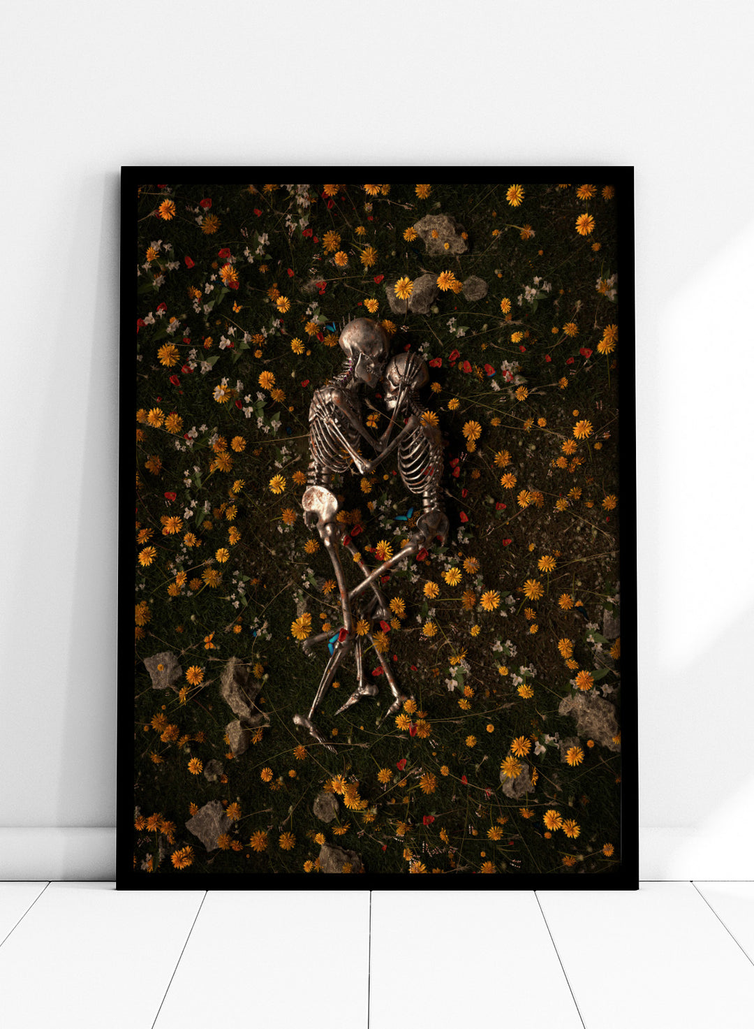 Skeletons In Love by Nicebleed is a surreal skeleton couple art print featuring intertwined skeletons in a floral field, modern aesthetic wall poster.
