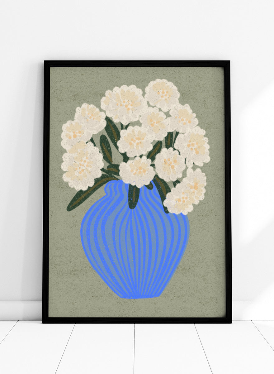 A stylized floral artwork showing a bouquet of off-white flowers with dark green leaves in a blue ribbed vase against a muted sage background. Shop White Blooms Blue Vase by Nikita Jariwala, a floral wall art print poster featuring white flowers in a striped blue vase with modern botanical style.