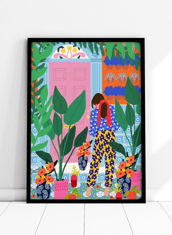 Illustration of a person in colorful pants standing in front of a pink door with plants and flowers. Floral Oasis Retreat by Rafaela Mascaro art print featuring woman in lush garden doorway, colorful plants, patterned tiles, and vibrant contemporary botanical wall art poster.