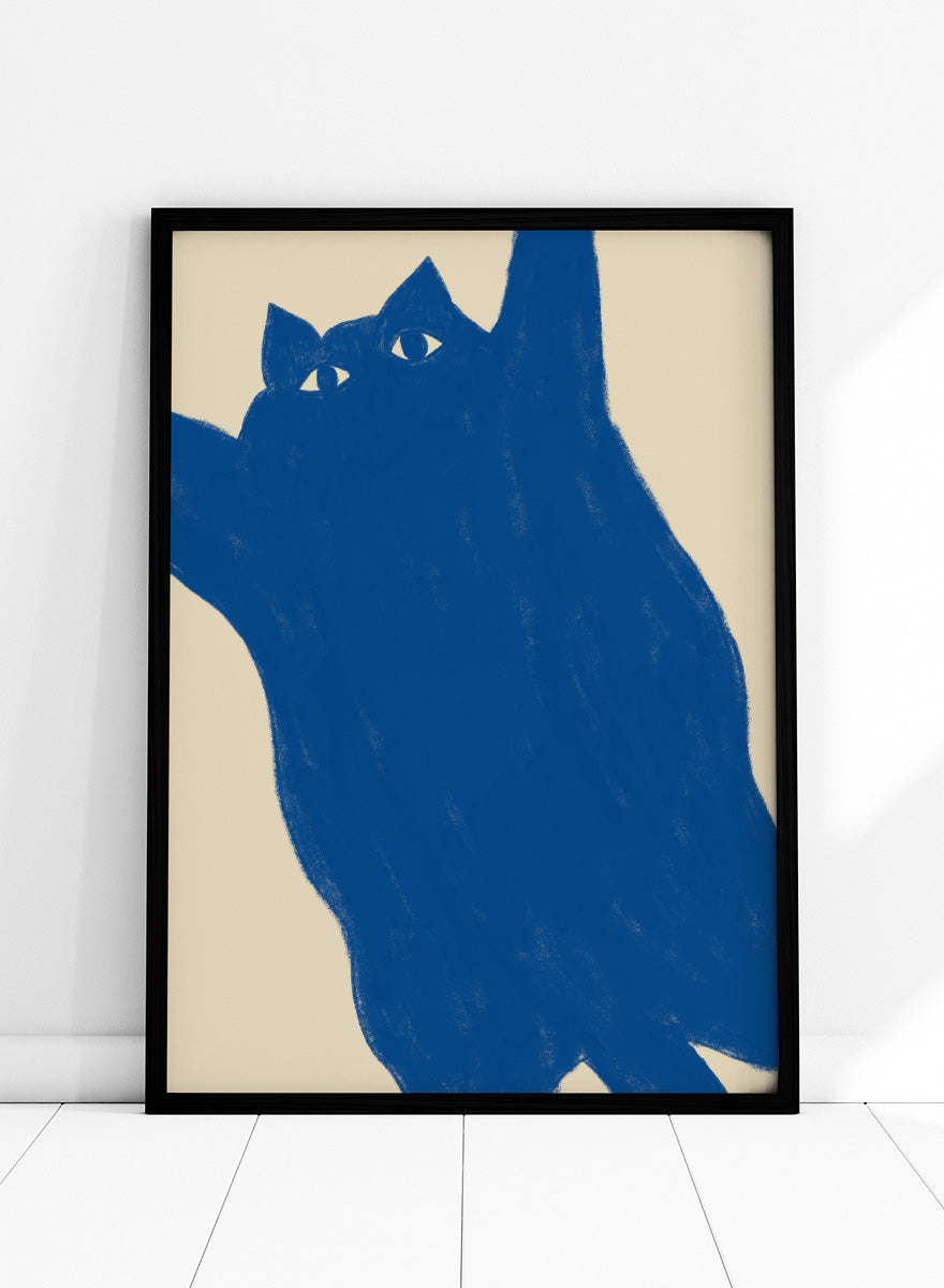 A minimalist art print featuring a bold blue cat silhouette with white eyes on a warm beige background. Playful Blue Cat by The Art Concept is a modern cat art print featuring a bold blue feline, oversized crop, and warm cream background.