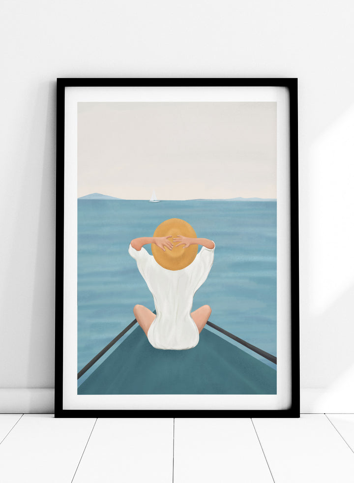 Person sitting on a dock over water wearing a white dress and straw hat. Ocean Escape by Flow Line features a woman sitting on a boat overlooking the sea, creating a coastal art print inspired by travel, summer, and ocean living.