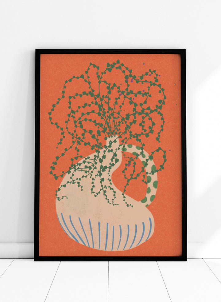 Shop Green Trailing Plant by Nikita Jariwala, a botanical wall art print poster featuring a trailing houseplant, cream vase, coral background, and bold green tones.