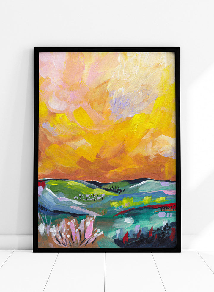 An abstract landscape painting featuring a dramatic yellow and orange sky over green and blue rolling hills, with textured brushstrokes. Shop Vibrant Sunset Landscape by Dirkie Nell, a colorful landscape art print featuring rolling green hills, wildflowers, and a warm golden sunset sky.