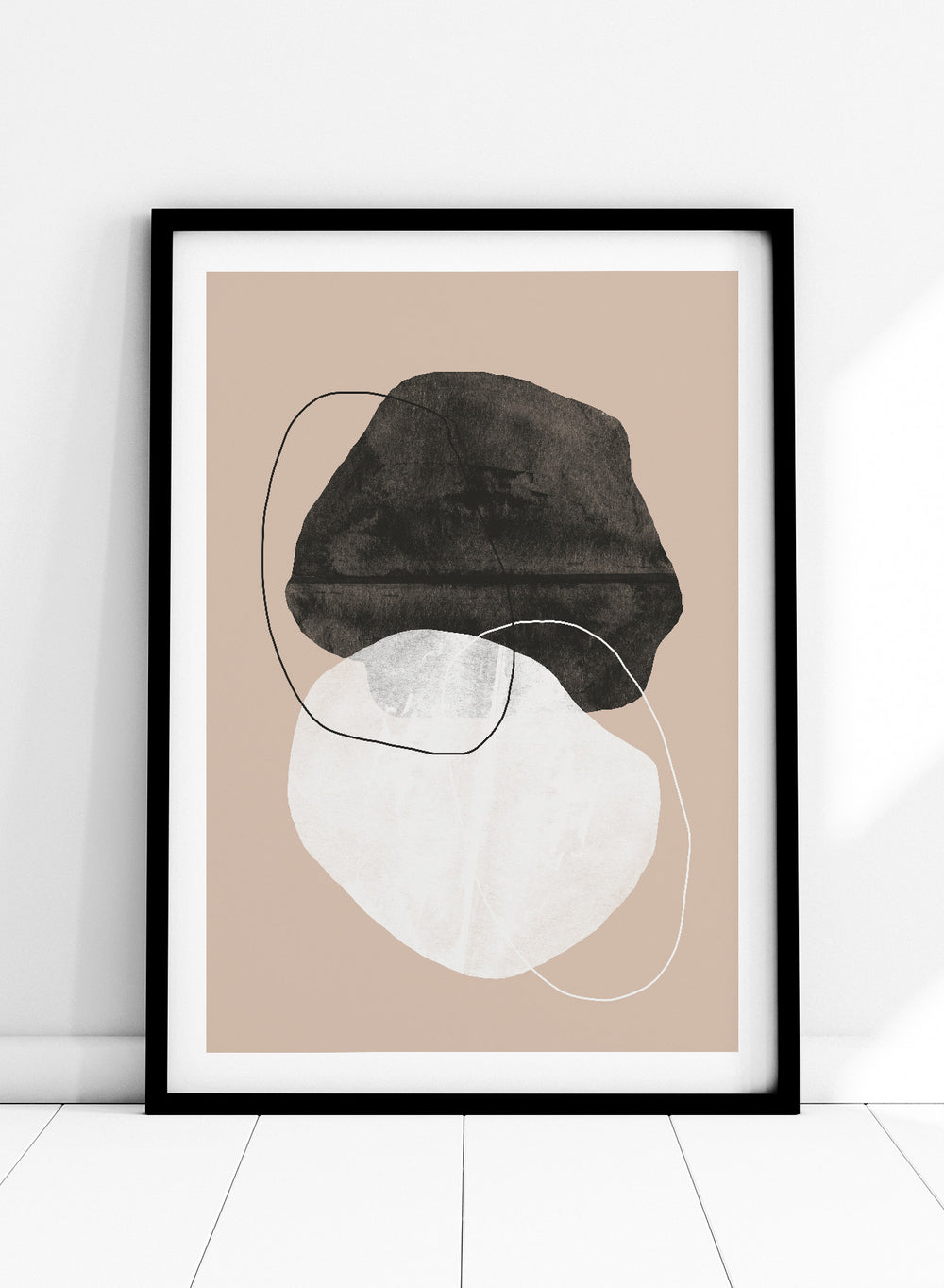 Abstract art piece with a black shape and white circle on a beige background. Earthy Abstractions by The MIUUS Studio is a minimalist abstract art print and wall poster featuring organic shapes, neutral tones, and modern textured design.