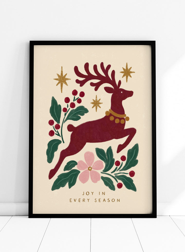 Shop Jumping Reindeer Joy by Katarzyna Gąsiorowska, a Christmas wall art print poster featuring a leaping reindeer, berries, greenery, stars, and festive holiday charm.