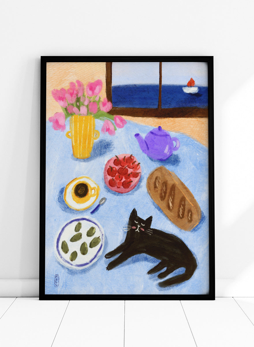 A colorful still life painting of a table scene with pink tulips in a yellow vase, a purple teapot, a bowl of strawberries, a cup of coffee, a loaf of bread, a black cat, and a window view of the sea with a small sailboat. Shop Relaxing Seaside Cat Breakfast by Dirkie Nell, a playful cat and food art print featuring breakfast, flowers, a sailboat, and a seaside view.