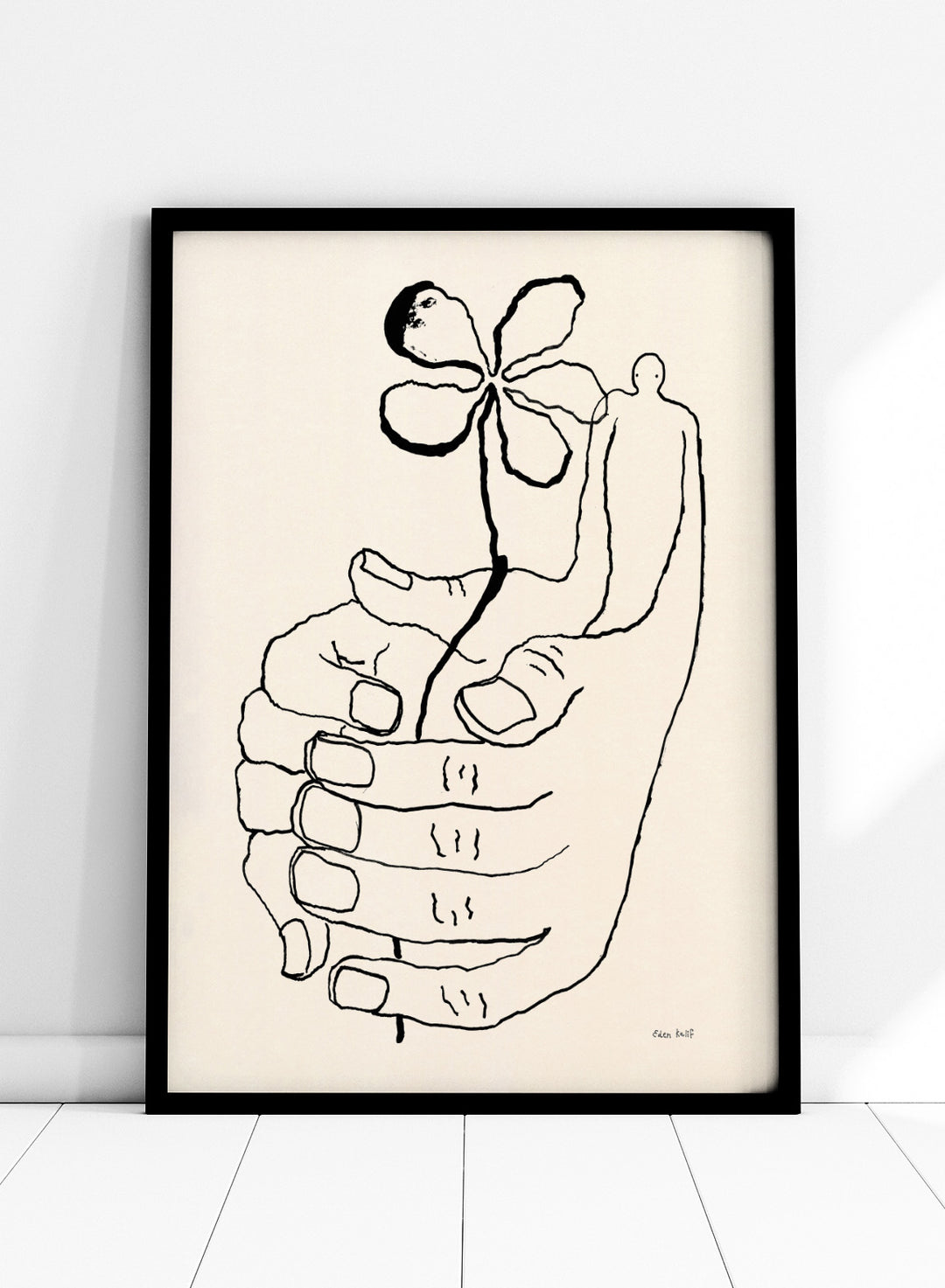 Black line drawing of a hand holding a flower on a beige background. Let It Grow by Eden Kalif is a modern line art print featuring a hand holding a flower with a human figure, designed as a minimalist contemporary wall poster.