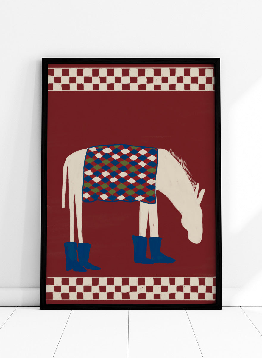 A stylized folk-art illustration of a white horse with a patterned blue, green, and red saddle blanket and blue boots, set against a dark red background with cream-and-red checkered borders at the top and bottom. Whimsical Donkey In Boots by The Art Concept animal art print featuring a white donkey in blue boots with a patterned blanket and rich red background.
