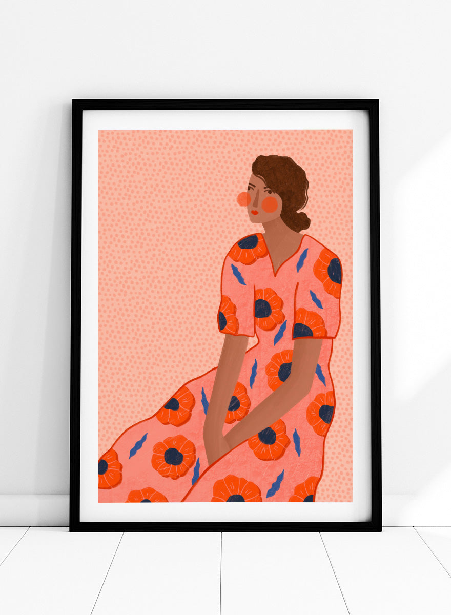 A stylized fashion illustration of a seated woman in a coral pink dress with large orange poppy motifs and blue leaf accents, shown with a white border and black frame. Stylish Poppy Portrait by Bea Müller floral woman art print featuring a pink dress covered in orange poppies and blue leaves for colorful modern wall decor.