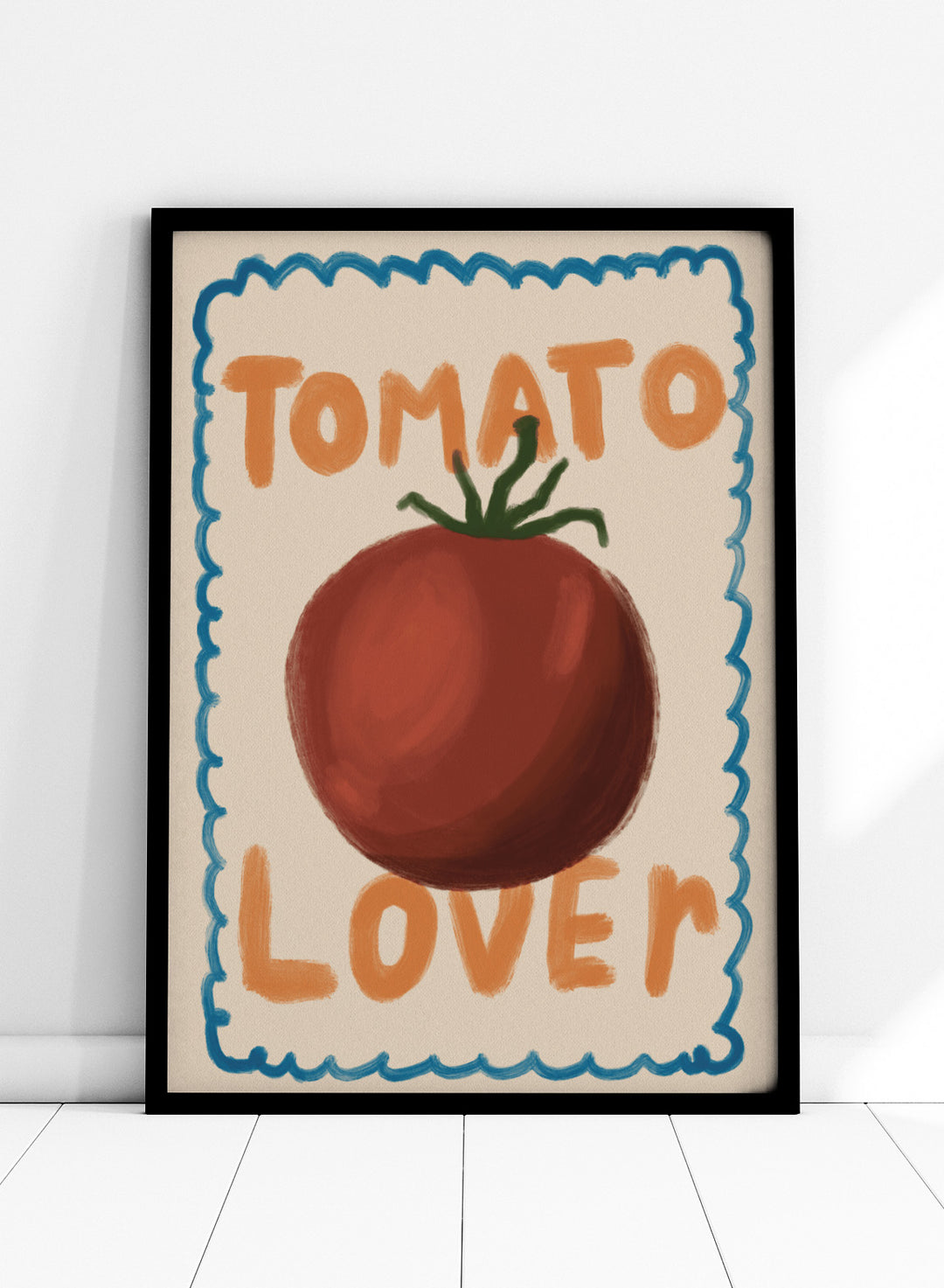 An art print featuring a painted red tomato with a green stem, surrounded by a scalloped blue border on a cream background. The words &