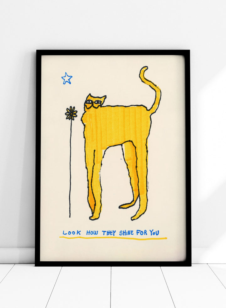 Yellow cat illustration with a flower and text on a beige background. Look How They Shine for You by Eden Kalif is a modern cat art print in yellow with text, a contemporary minimalist wall poster with playful form and expressive line work.