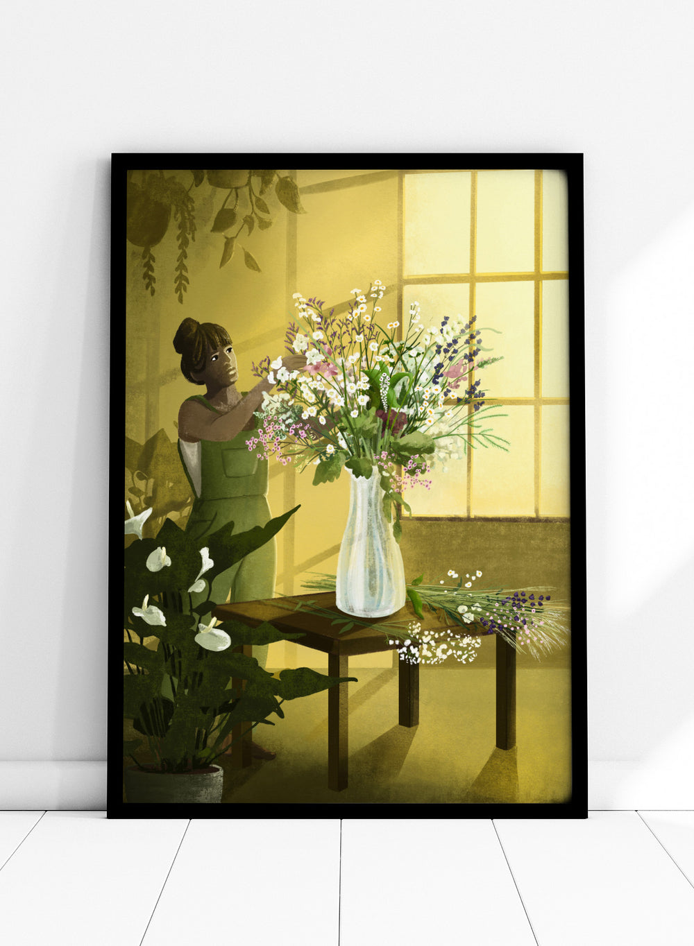 Woman in a green dress holding a bouquet of flowers in a softly lit room. In the Cracks of Light I Dream by Goed Blauw is a floral art print and wall poster featuring a woman arranging flowers in warm window light.