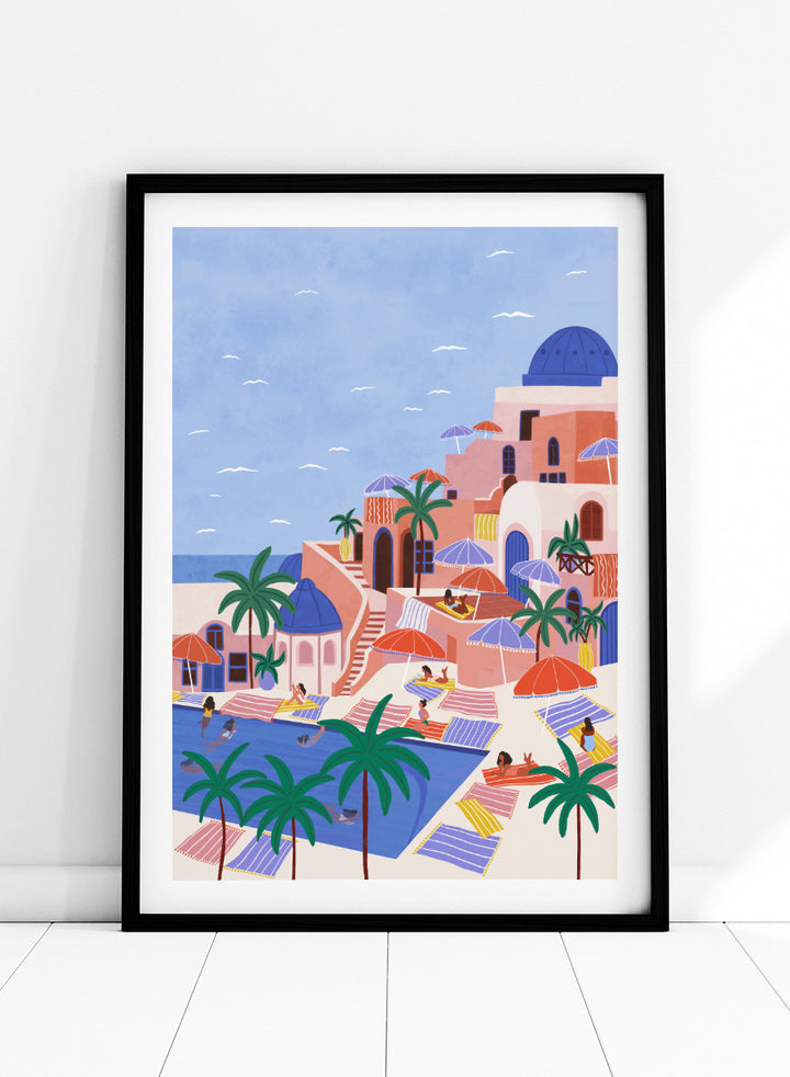 A stylized art print depicting a Mediterranean resort scene with palm trees, beach umbrellas, lounge chairs, a swimming pool, and pastel-colored buildings under a light blue sky. Mediterranean Poolside Retreat by Ceyda Alasar travel art print featuring a colorful coastal resort, palm trees, sunbathers, striped umbrellas, and sea views.