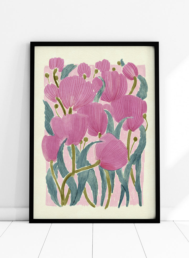 A framed art print featuring a stylized illustration of pink tulips with textured green leaves on a light cream background. Shop Pink Tulips by Katie O&