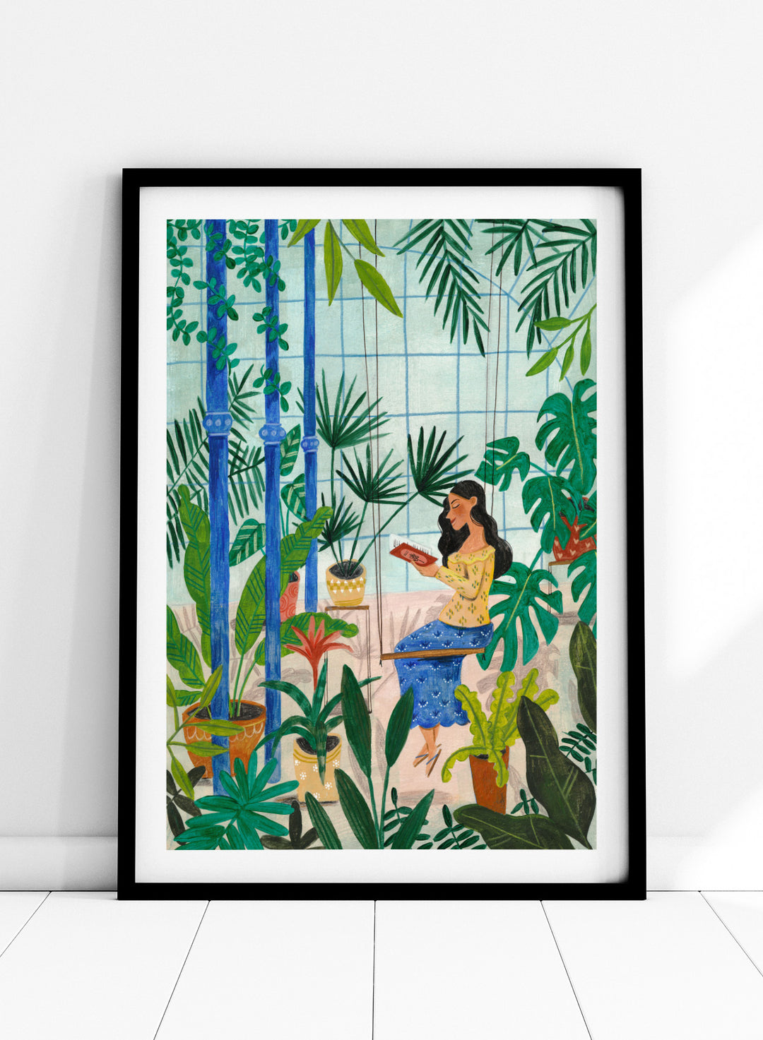 Woman sitting among plants in a room with bamboo and various greenery. Botanical Greenhouse Reader by Caroline Bonne Müller is a fine art print and wall poster featuring a woman reading in a lush indoor garden filled with tropical plants.