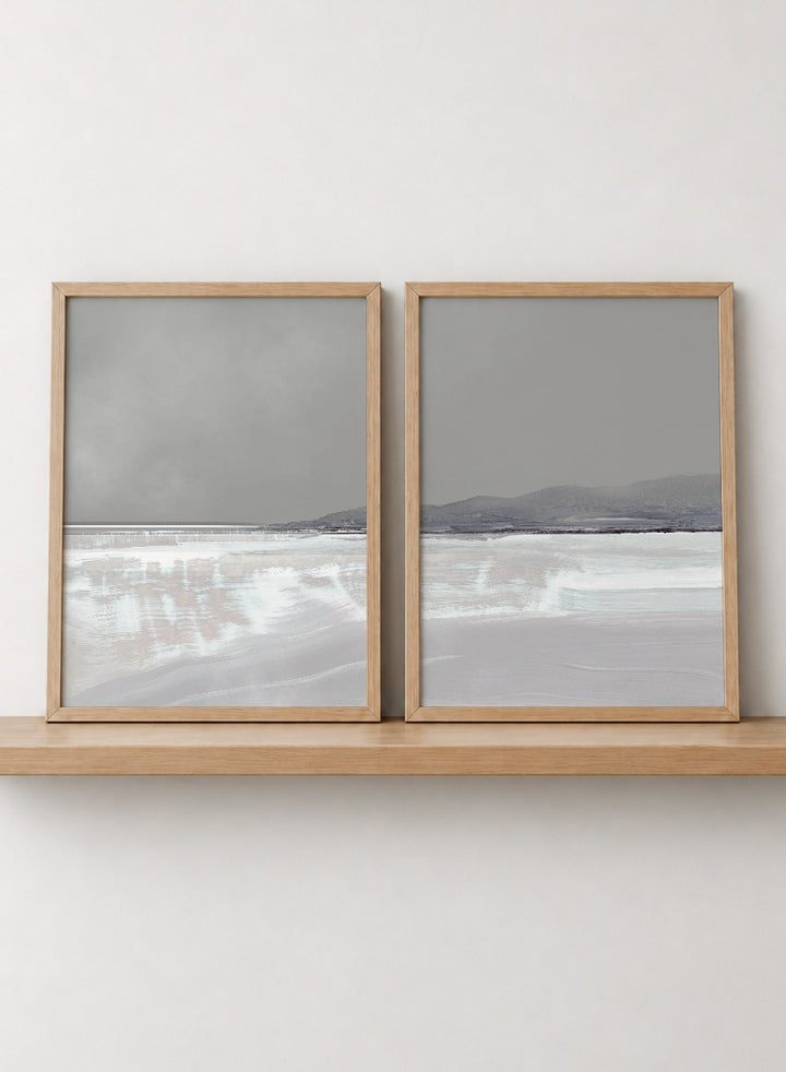 Shop Tides by Dan Hobday, a set of 2 coastal landscape wall art prints posters featuring calm water, distant hills, and soft gray-blue tones.