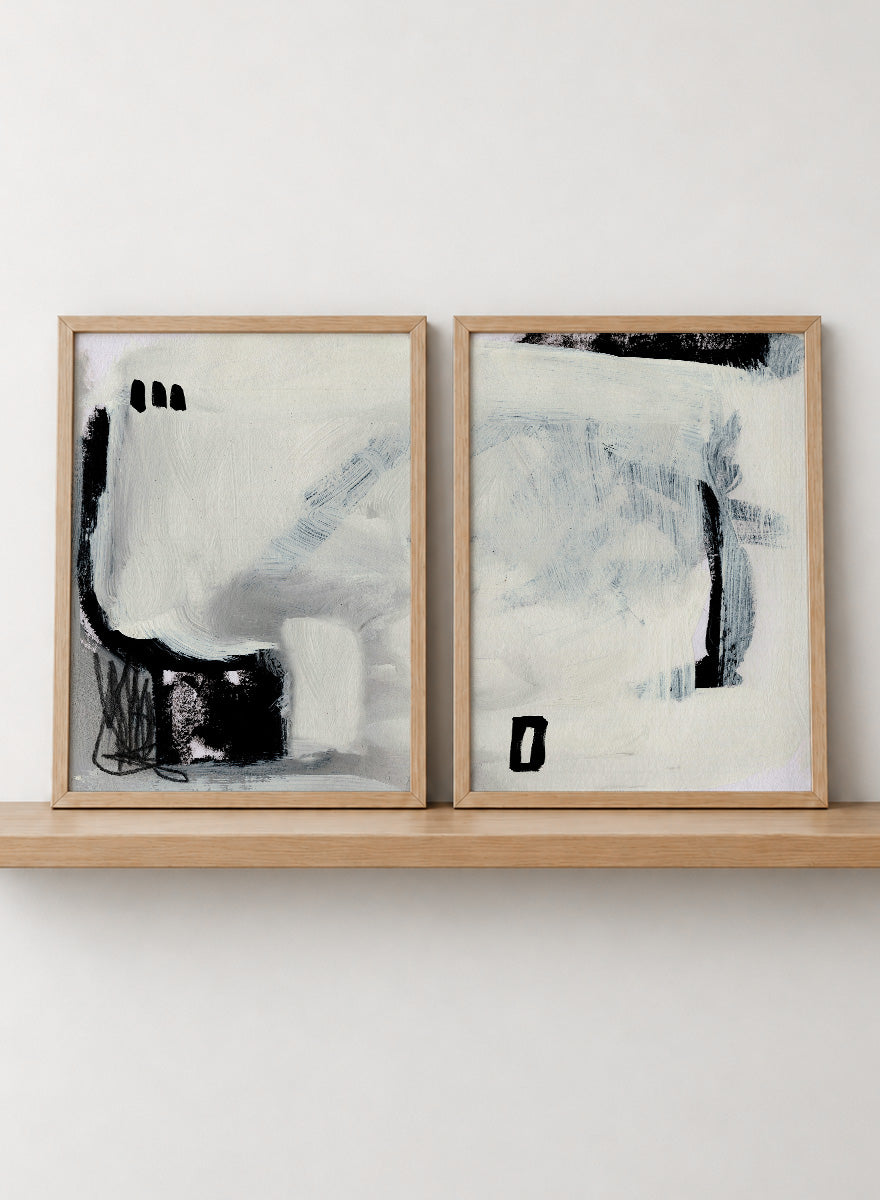Shop Beyond by Dan Hobday, a set of 2 abstract wall art prints posters featuring expressive black forms, layered brushwork, and soft white and blue tones.