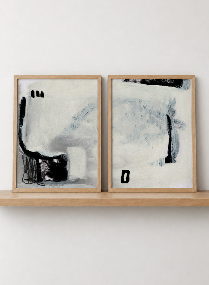 Shop Beyond by Dan Hobday, a set of 2 abstract wall art prints posters featuring expressive black forms, layered brushwork, and soft white and blue tones.